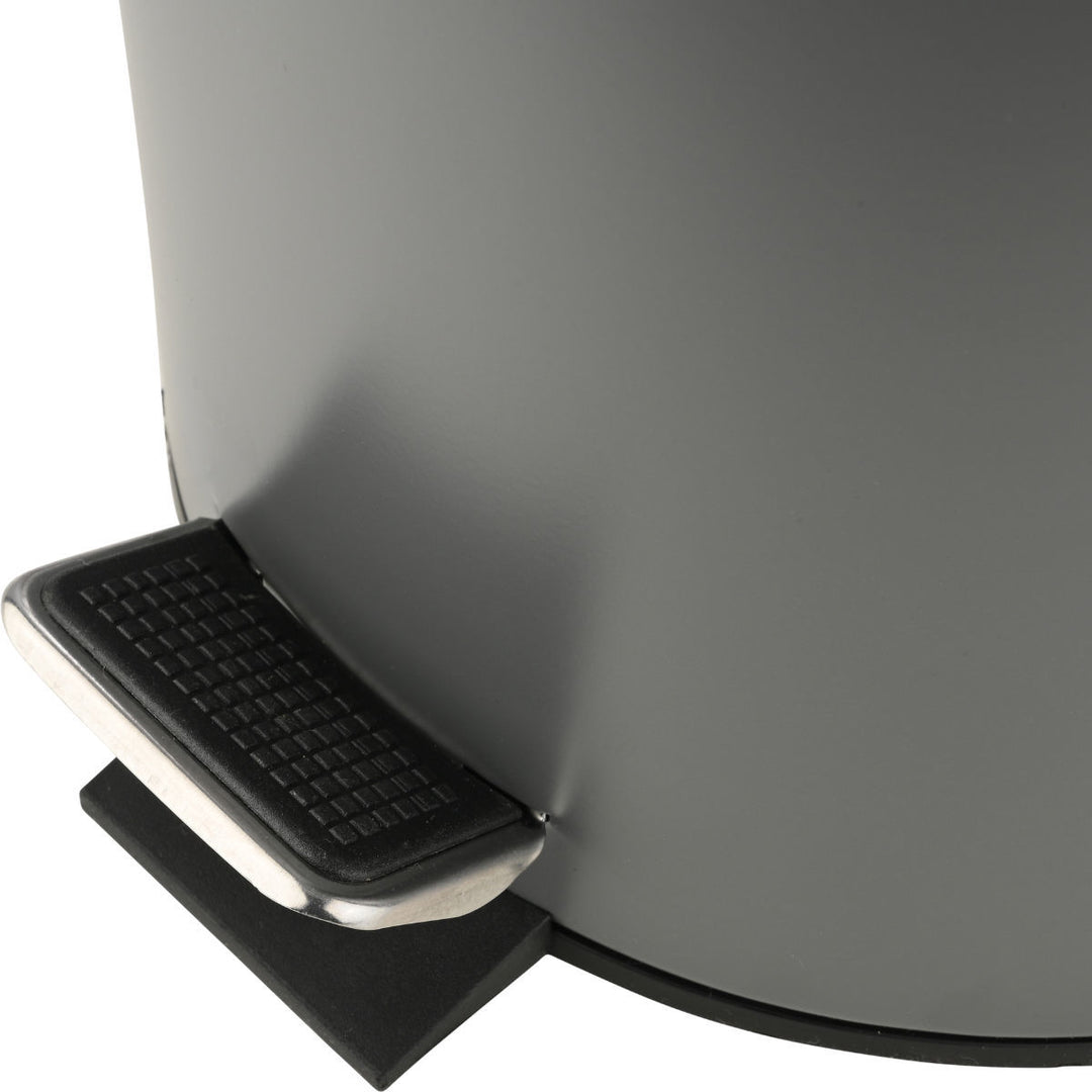 Λεπτομέρεια από το πεντάλ γκρι κάδου απορριμμάτων με μεταλλικό μηχανισμό, ενσωματωμένο σε μοντέρνο τετράγωνο σχεδιασμό.