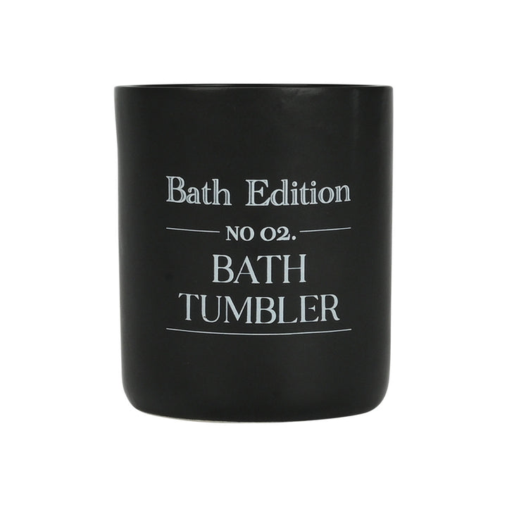 Μαύρο ποτήρι μπάνιου με λευκή επιγραφή “Bath Tumbler” σε απλό φόντο, παρουσιάζοντας καθαρό και μοντέρνο σχεδιασμό.