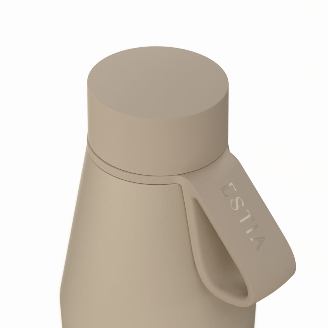 Κοντινή λήψη της βάσης του μπεζ θερμός Flow 500ml της Estia με διακριτικό λογότυπο και πληροφορίες κατασκευής.