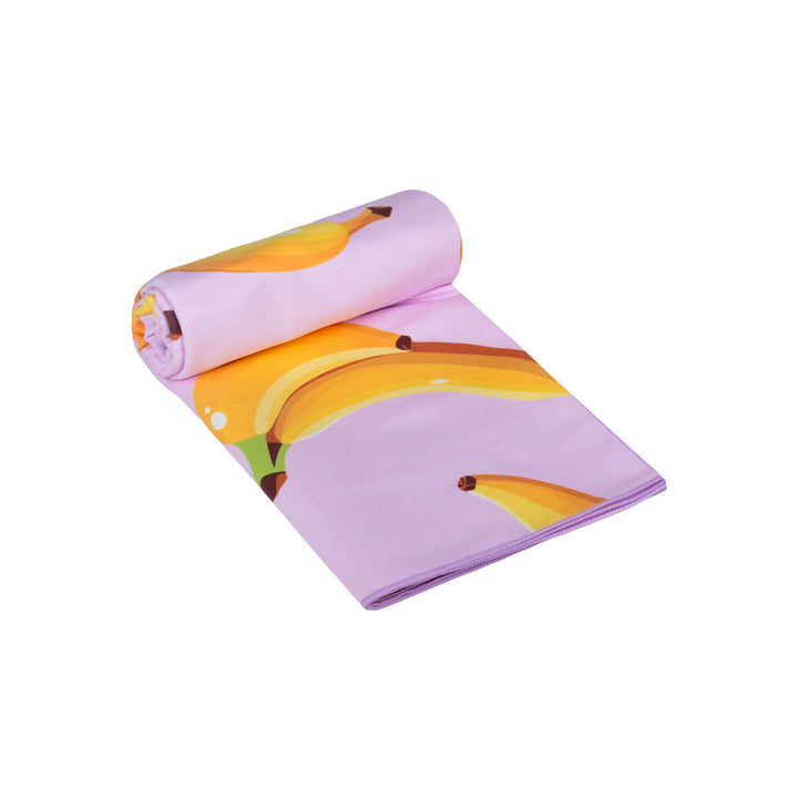 Διπλωμένη πετσέτα θαλάσσης microfiber με λιλά χρώμα και σχέδιο μπανάνας, ελαφριά, απορροφητική και εύκολη στη μεταφορά για τις καλοκαιρινές εξορμήσεις.