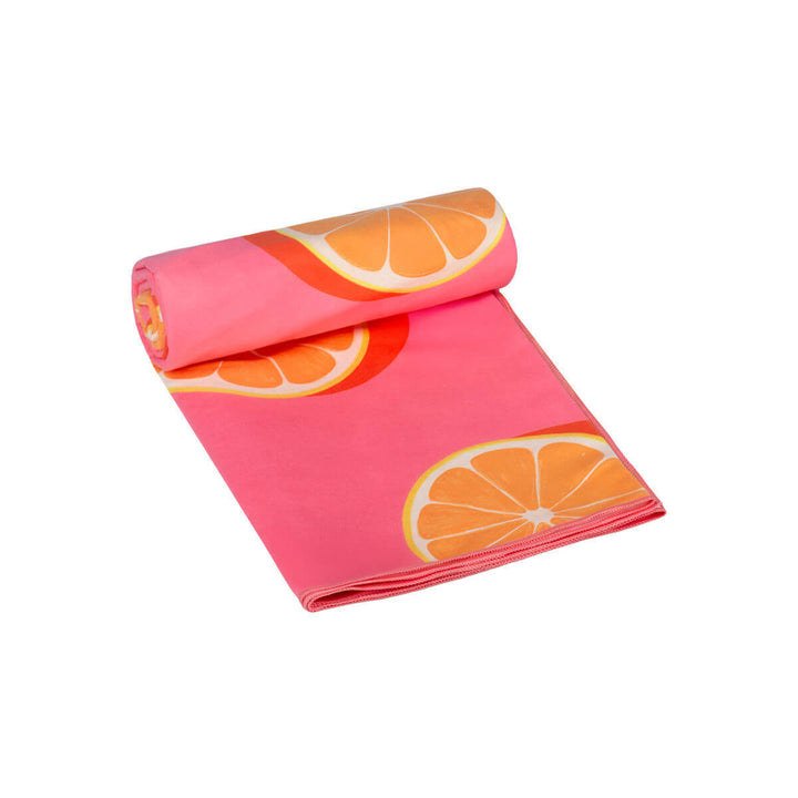 Διπλωμένη πετσέτα θαλάσσης microfiber με ροζ φόντο και μεγάλες φέτες πορτοκαλιού, ελαφριά, απορροφητική και εύκολη στη μεταφορά για το καλοκαίρι.
