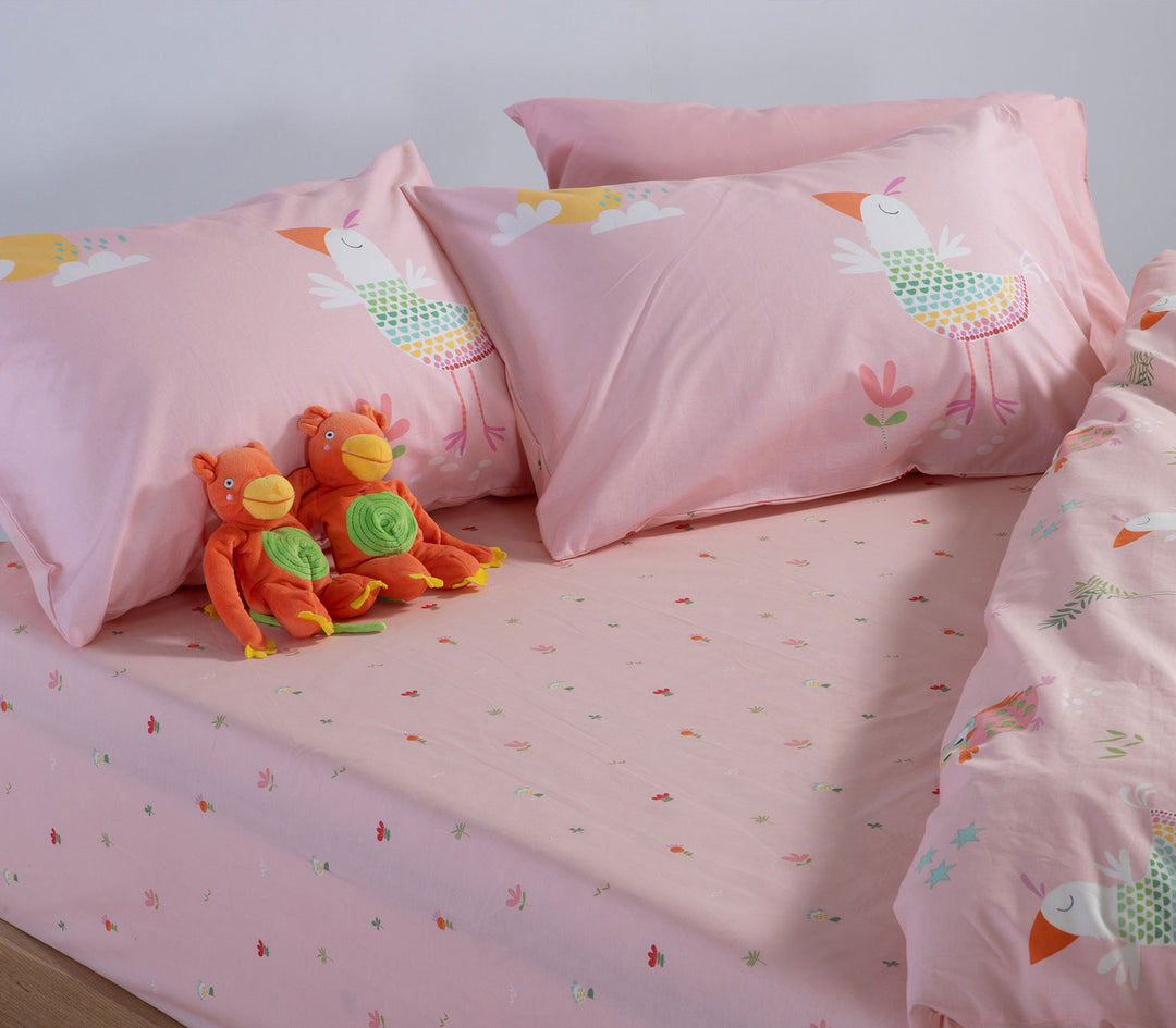 Ροζ παιδικό σετ σεντονιών Birds Mania της Nef-Nef Homeware στρωμένο σε κρεβάτι με διακοσμητικά λούτρινα παιχνίδια.