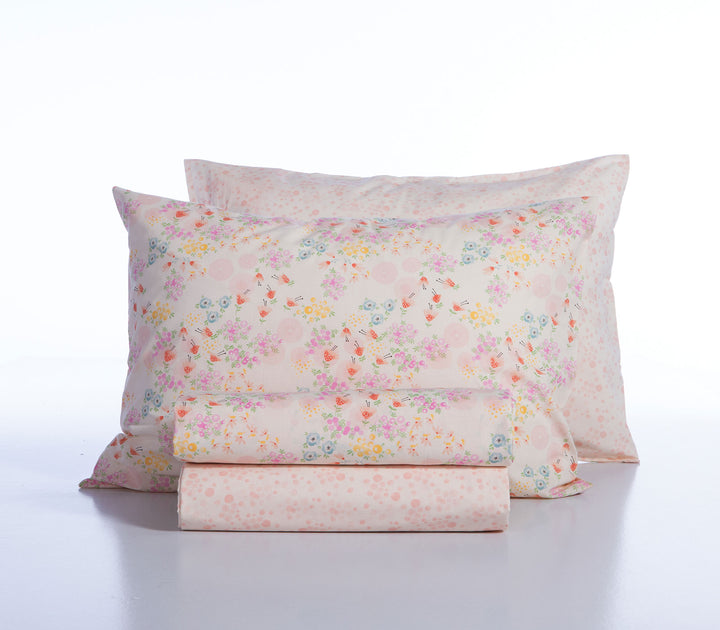 Ροζ παιδικά σεντόνια Blossom Day της Nef-Nef Homeware διπλωμένα με λουλουδάτο σχέδιο σε ουδέτερο φόντο.