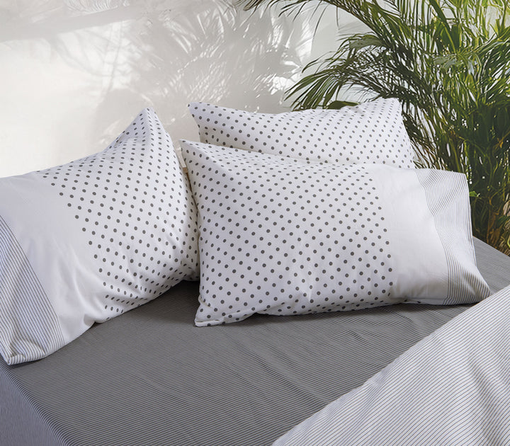 Εκρού μαξιλαροθήκες ύπνου Nef-Nef Homeware με γκρι πουά σχέδιο σε κρεβάτι με ριγέ σεντόνια.