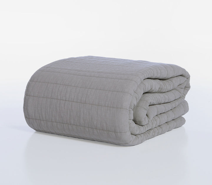 Διπλωμένο γκρι κουβερλί Nef-Nef Homeware με καπιτονέ ραφές τοποθετημένο πάνω σε λευκό φόντο στούντιο.