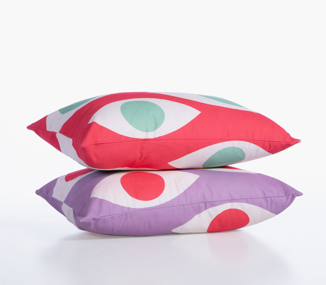 Δύο διακοσμητικές μαξιλαροθήκες High Option της Nef-Nef Homeware με μοτίβο ματιών σε κόκκινο και μωβ χρώμα σε λευκό φόντο.
