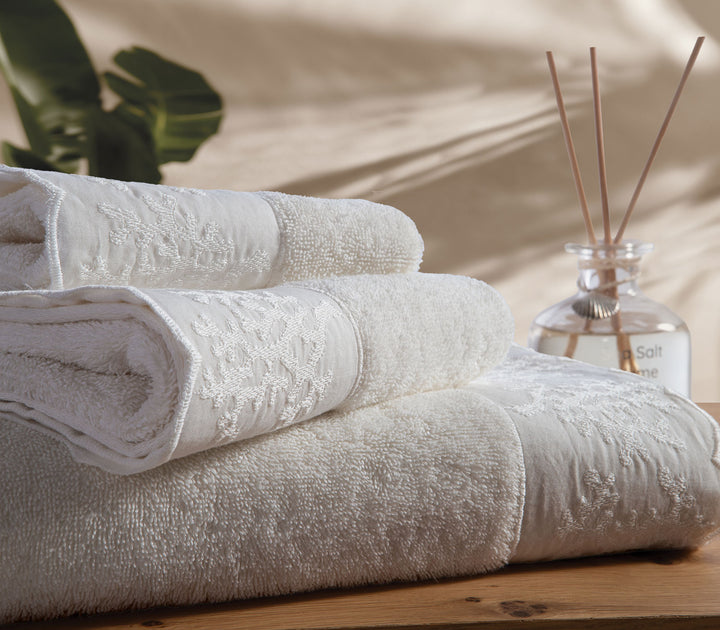 Κοντινό πλάνο σε βαμβακερές πετσέτες Nef-Nef Homeware σε λευκή και μέντα απόχρωση με ανάγλυφο διακοσμητικό σχέδιο.