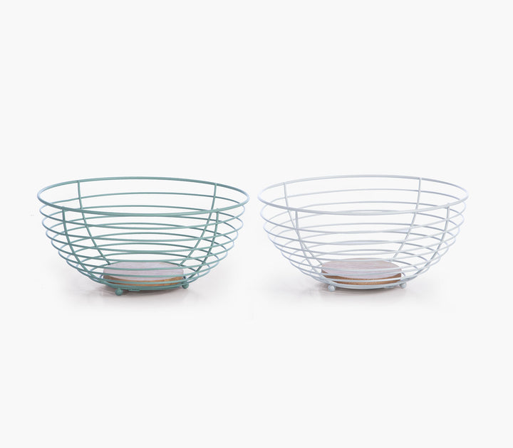 Μεταλλικά καλάθια φρούτων σε πράσινο και λευκό χρώμα με ξύλινη βάση σε λευκό minimal φόντο.