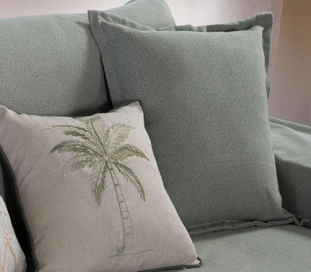 Διακοσμητικό μαξιλάρι Loen της Nef-Nef Homeware σε πράσινη απόχρωση με γεωμετρικό σχέδιο πάνω σε καναπέ σαλονιού.