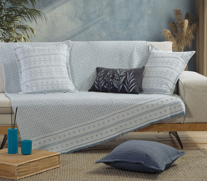 Ριχτάρι πολυθρόνας Ishmar Blue της Nef-Nef Homeware σε καναπέ με διακοσμητικά μαξιλάρια σε μπλε αποχρώσεις.