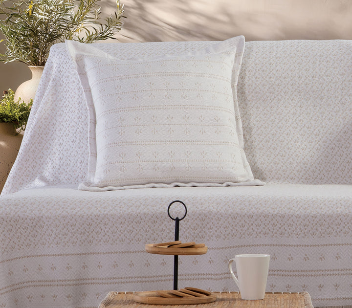 Ριχτάρι πολυθρόνας Ishmar της Nef-Nef Homeware σε μπεζ χρώμα απλωμένο σε καναπέ σαλονιού με διακοσμητικό μαξιλάρι.