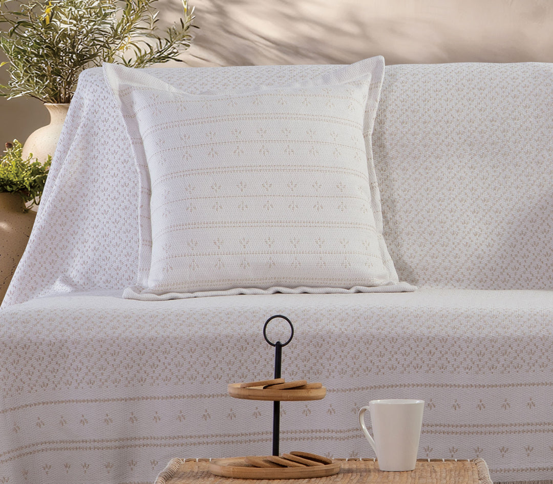 Μπεζ διακοσμητικό μαξιλάρι Ishmar της Nef-Nef Homeware τοποθετημένο σε καναπέ με ριχτάρι της ίδιας συλλογής.