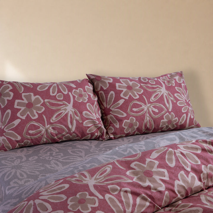Μαξιλαροθήκες ύπνου Harmony Nef-Nef Homeware σε ροζ απόχρωση με έντονο λουλουδάτο σχέδιο, τοποθετημένες σε κρεβάτι.
