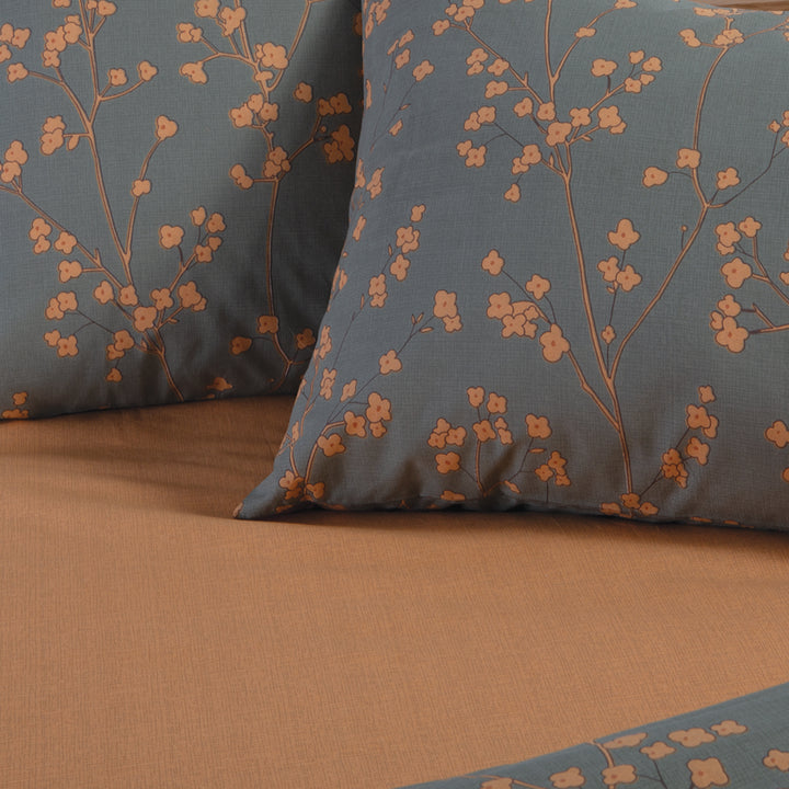 Κοντινή όψη πράσινης παπλωματοθήκης Floriva Nef-Nef Homeware με πορτοκαλί λουλουδάτο μοτίβο και μονόχρωμη πίσω όψη.