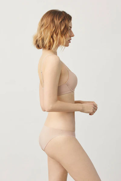 Μοντέλο με μπεζ αόρατο εσώρουχο bikini από πλάγια όψη.