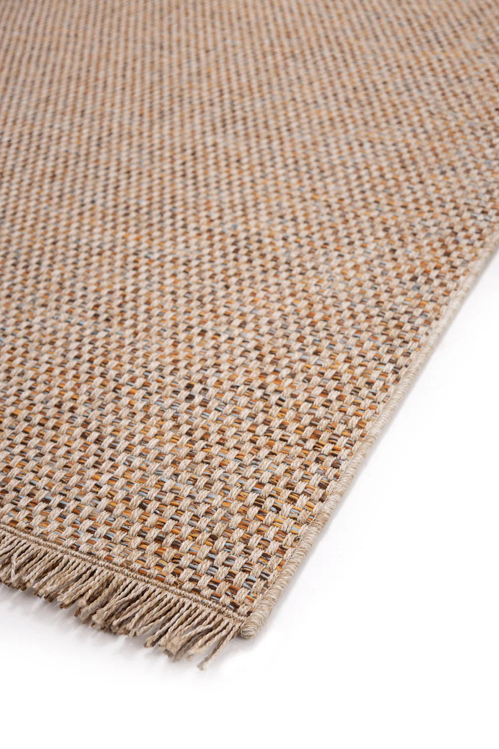 Λοξή κοντινή λήψη της άκρης του χαλιού με κρόσσια, σε χρώματα μπεζ, ώχρας και καφέ με διακριτικές γκρι λεπτομέρειες.