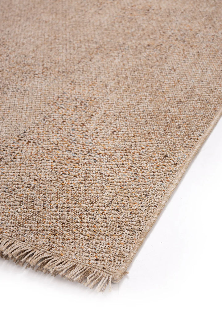 Πλάγια κοντινή λήψη υφής χαλιού σε μπεζ, καφέ, πορτοκαλί και γκρι αποχρώσεις, με λεπτομέρειες της πλέξης και κρόσσια.