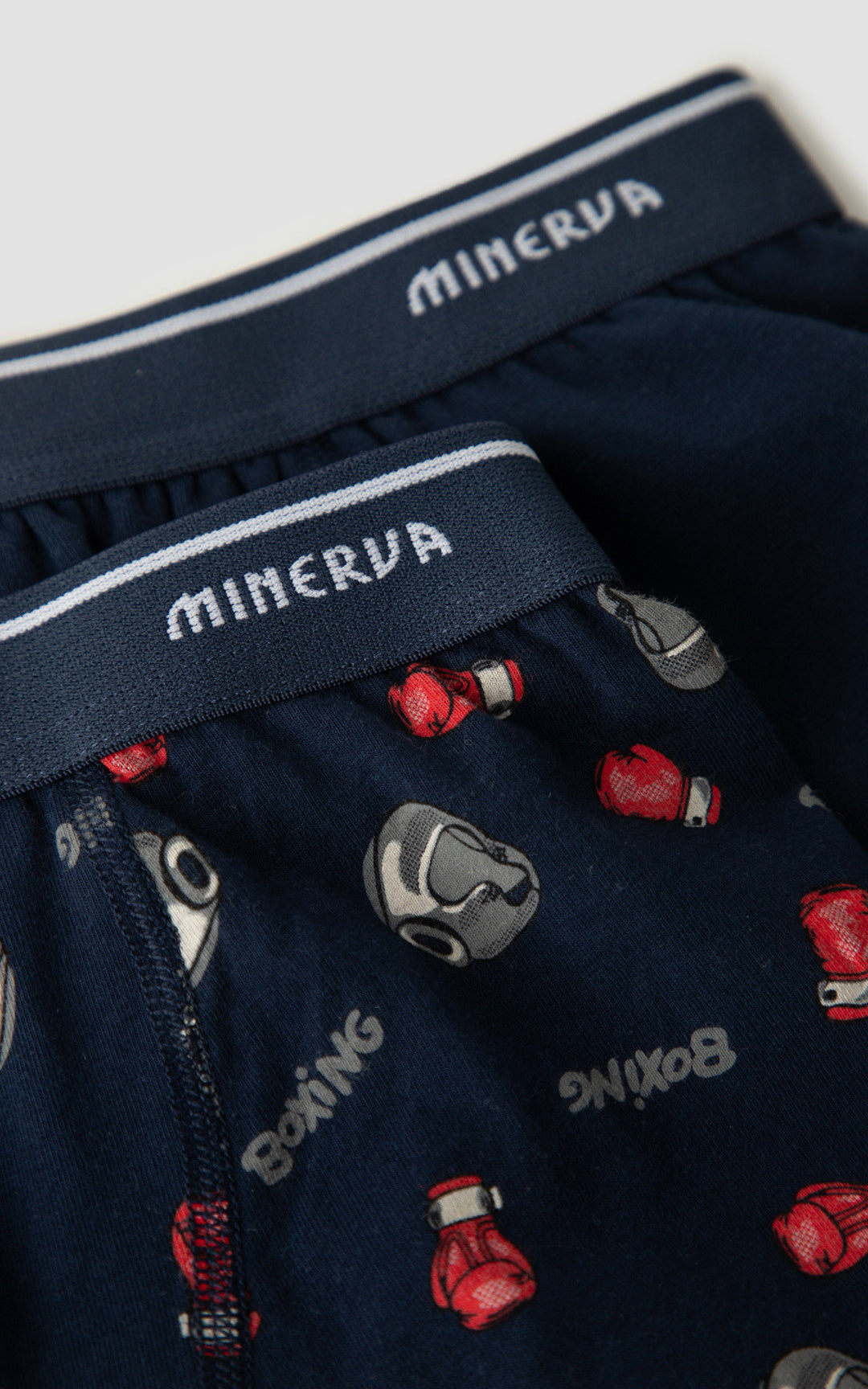 Κοντινή λήψη παιδικών boxer Minerva με σχέδια γαντιών πυγμαχίας και εξωτερικό λάστιχο μέσης με λογότυπο.